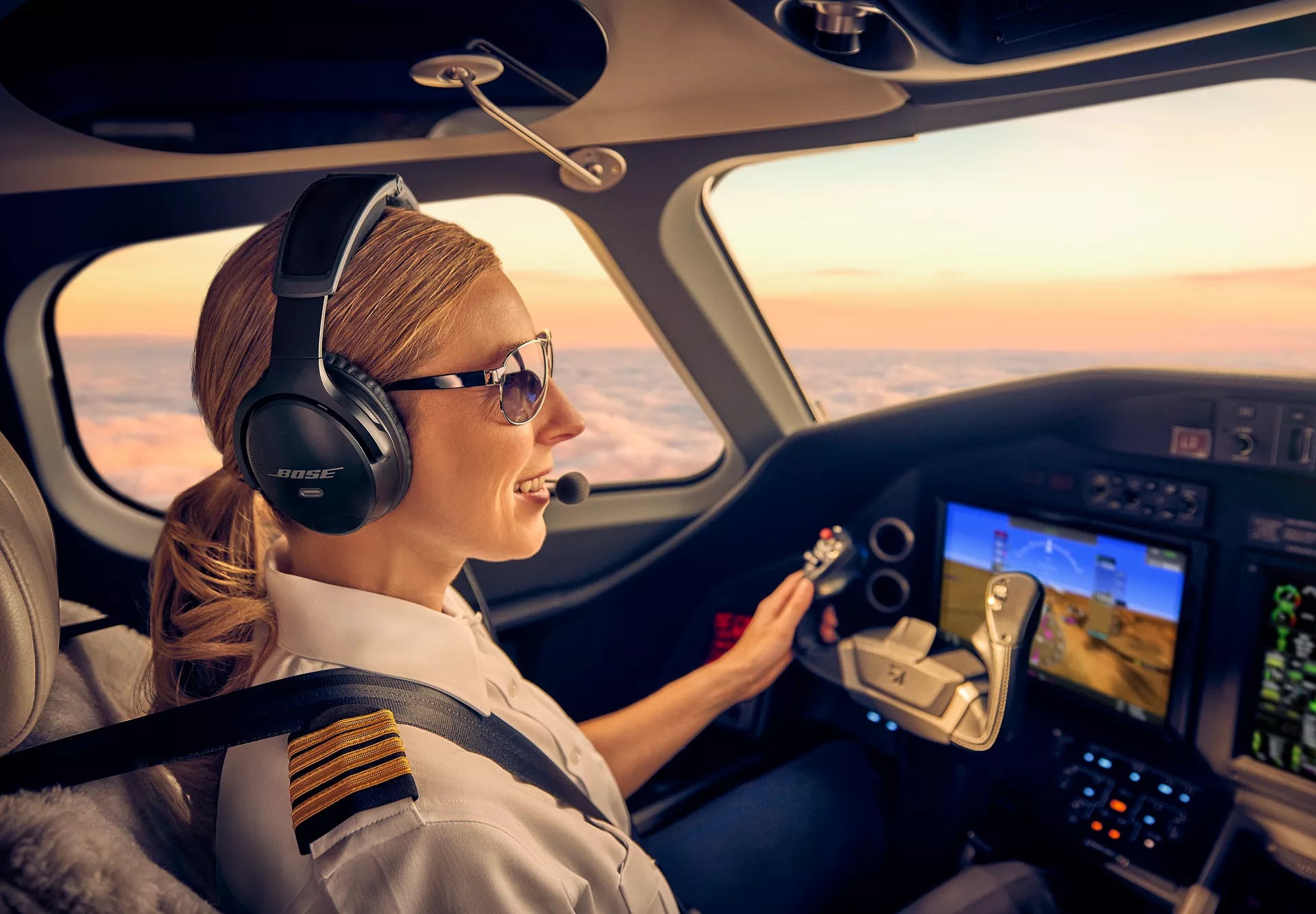 Female commercial pilot in an airplane cockpit wearing a Bose A30 Aviation Headset.