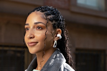 Woman wearing Bose Ultra Open Earbuds.